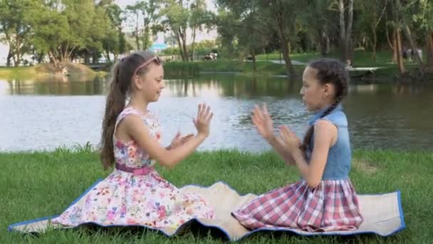 Dos Niñas Felices Sientan Juegan Parque Césped Junto Río Atardecer — Vídeo de stock