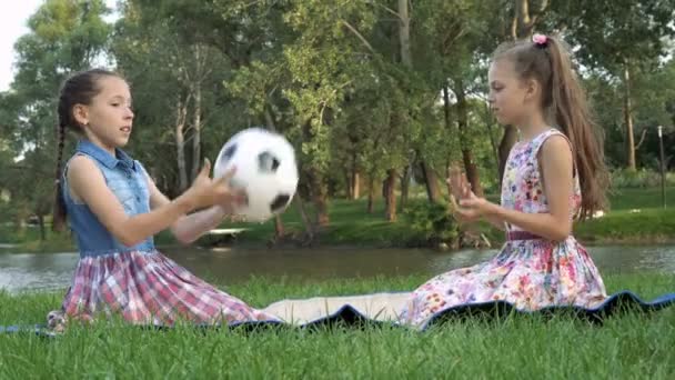 Two Little Girls Play Soccer Ball Sitting Grass Sit Sunset — Stock Video