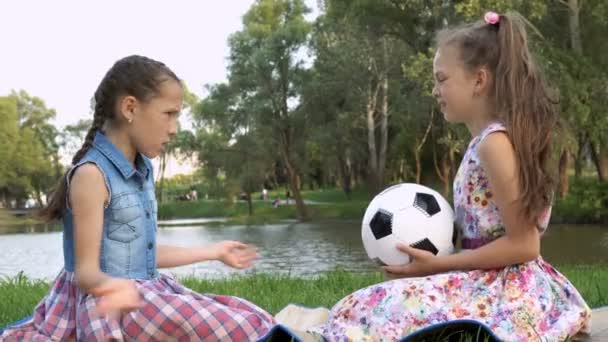 Two Little Girls Sitting Park Grass Each Other Holding Soccer — Stock Video