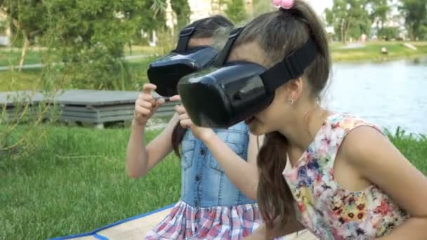 Duas Meninas Capacetes Realidade Virtual Brincando Parque Grama Junto Rio — Vídeo de Stock