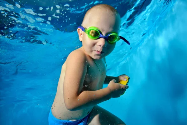 Niño Está Nadando Bajo Agua Piscina Sobre Fondo Azul Mira — Foto de Stock