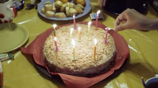 閉じる 黄色のテーブル クロスの上の赤いナプキンでプレートの上に立つ ケーキの上のロウソクのアップ Fps — ストック動画