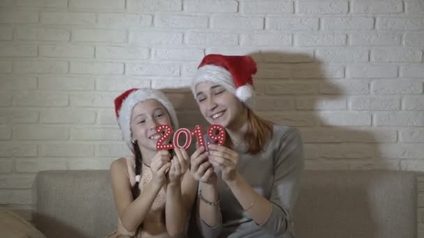 Two Little Girls Santas Hats Holding Red Numbers 2019 Sitting — Stock Video