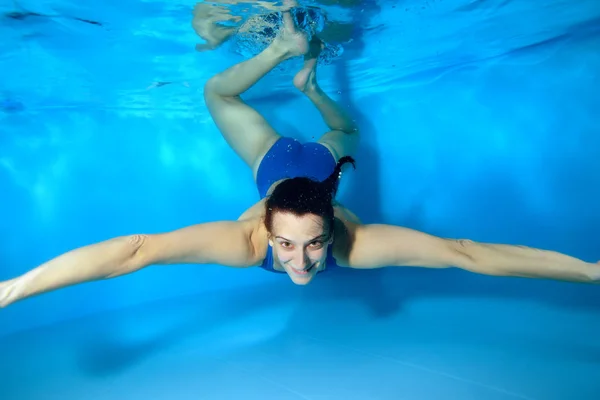Sports Female Instructor Dives Bottom Pool Blue Swimsuit Looks Camera — Stock Photo, Image