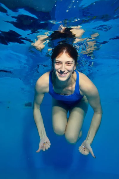 Bir Kız Havuzdaki Suyun Altında Mavi Bir Arka Plan Üzerinde — Stok fotoğraf