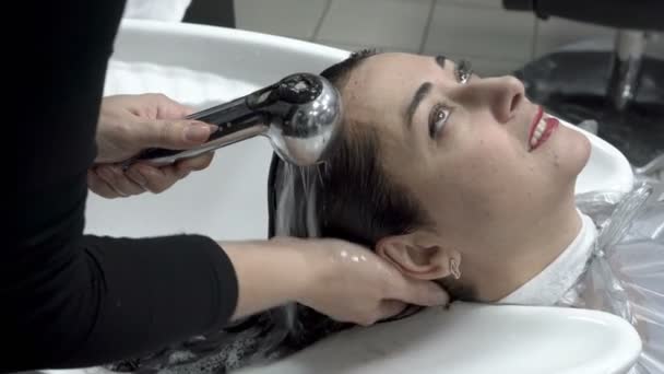 美发师在美容院的着色程序结束后, 洗掉女孩头发上的油漆。护发。闭上你的嘴4k. 25 帧/秒 — 图库视频影像