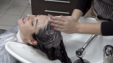 Kadın Kuaför Güzellik Salonu baş şampuan oryantal kız lathers. Saç Bakımı. Yakın çekim. 4 k. 25 fps