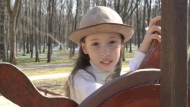 Sevimli küçük kız Spring Park oyun alanında geminin dümen bulunmaktadır. Portre. Kapat şunu. 4k. 25 fps.