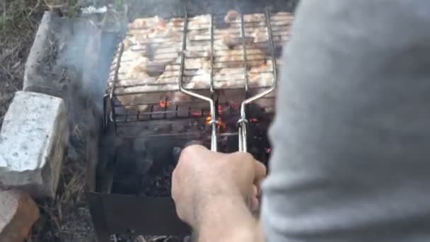 Człowiek przygotowuje się do grillowania na świeżym powietrzu. On także pieczeń kawałków soczyste mięsa na węgle. Piknik w plenerze. Z bliska. Widok z góry. 4 k. 25 fps. — Wideo stockowe