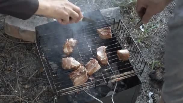 Familjen stek köttbitarna på grillen på kolen utomhus. Grilla gott grillat kött. Picknick i naturen. Närbild. Vyn från toppen. 4 k. 25 fps. — Stockvideo