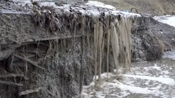 De stroom van vuile, modderige water stroomt af van een stroom een waterval in de rivier in het voorjaar. Smeltende sneeuw. Milieuvervuiling. Close-up 4k. 25 fps. — Stockvideo