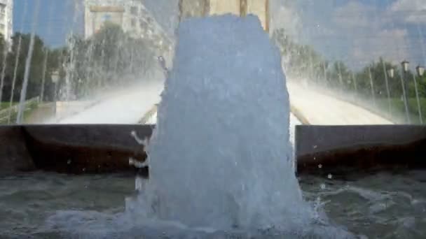 Närbild av bubblande vattenstråle i fontänen på bakgrunden av stadslivet på sommaren på en solig dag. Närbild. 4K — Stockvideo