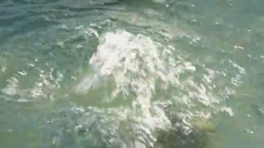 Çeşmeden su yüzeyinde güneşli bir günde yaz aylarında bir su jeti vardır. Üst yan görünüm. 4k.