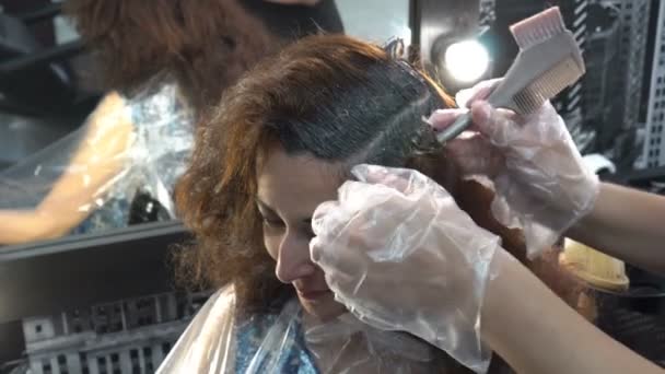 A lányok haja van festva a fodrász boltban. A Barber alkalmazott ecsettel a haját. Közelről. 4k — Stock videók