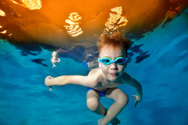 Sportowy chłopiec pływacki pod wodą w basenie. Pozowanie do kamery w goglach pływackich. Dolny widok od dołu puli. Portret. Fotografia podwodna. Widok poziomy — Zdjęcie stockowe