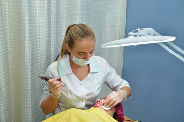 Güzellik salonunda, bir ana güzellik, bir sarışın kalıcı makyaj dudakları Avrupa kız yapıyor, bir pamuk Pad ile dudakların köşelerini siliyor. Kapat şunu. Görüntünün yatay yönü