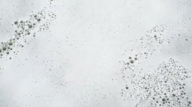 Su yüzeyinde kabarcıklarla sabun köpüğü yakın çekim. 4k.