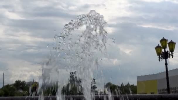 Close-up do jato de água da fonte da cidade contra o céu azul . — Vídeo de Stock