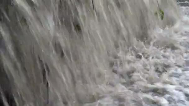 Plan extrêmement rapproché de l'écoulement rapide d'eau boueuse boueuse se précipitant dans la rivière. Petite cascade. Ferme là. 4K .