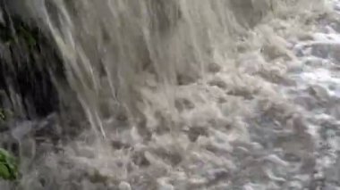 Son derece yakın-up nehir içine acele çamurlu kabarcıklanma su türbülanslı akışı. Küçük bir şelale. Kapat şunu. 4k.