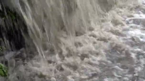 Extremamente close-up do fluxo turbulento de água borbulhante enlameada correndo para o rio. Pequena cascata. Fecha. 4K . — Vídeo de Stock