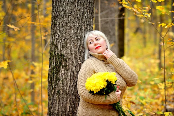 화창한 가을 날에 공원에서 포즈를 취하는 가을 숲과 섬세한 니트 드레스에서 아름다운 금발. 그녀의 입술에 주홍 립스틱. 여성의 크기 플러스 xxl. 가로 보기 — 스톡 사진
