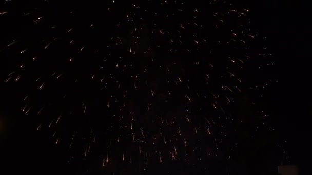 Bela saudação sobre o telhado da casa no céu noturno. Explosões multicoloridas num fundo preto. Férias. Conceito. Fecha a porta. 4K . — Vídeo de Stock