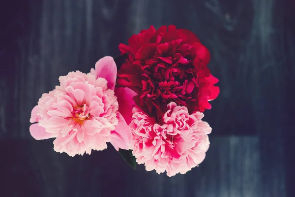 Ahşap siyah arka plan üzerine gül peonies güzel buket. Dekor ve sanat kavramı.