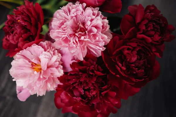 Ahşap siyah arka plan üzerine gül peonies güzel buket. Dekor ve sanat kavramı.