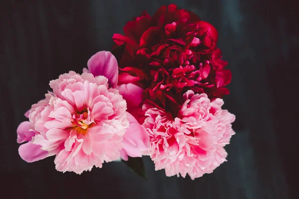Ahşap siyah arka plan üzerine gül peonies güzel buket. Dekor ve sanat kavramı.