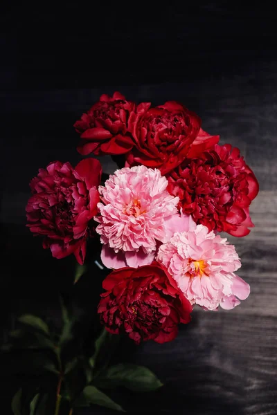 Ahşap siyah arka plan üzerine gül peonies güzel buket. Dekor ve sanat kavramı.