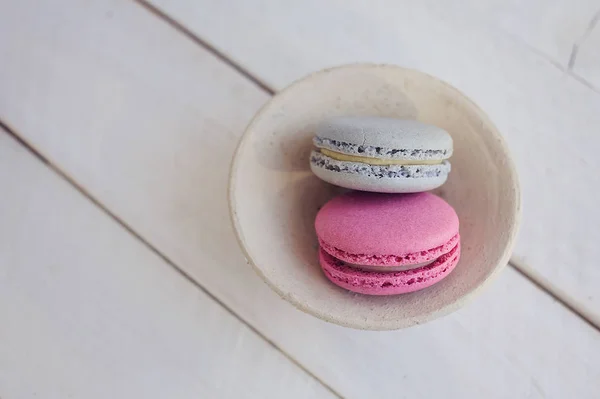 Renkli macaroons yukarıdaki üzerinden Beyaz ahşap zemin üzerinde. Metin için yer. 