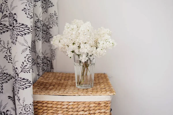 Bouquet of lilacs in a glass vase. Lilac flowers in vintage style against white background.