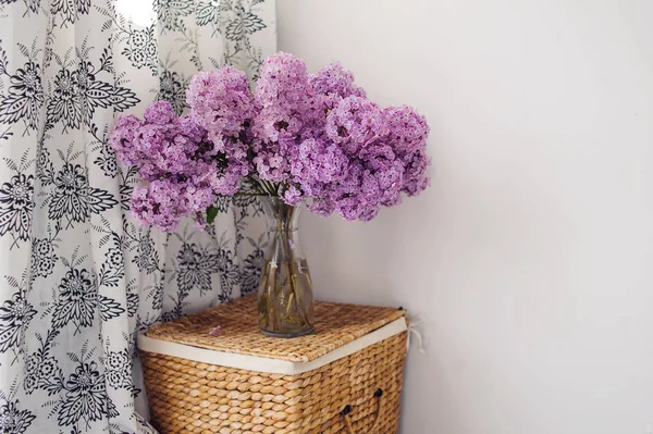 Bouquet of lilacs in a glass vase. Lilac flowers in vintage style against white background.