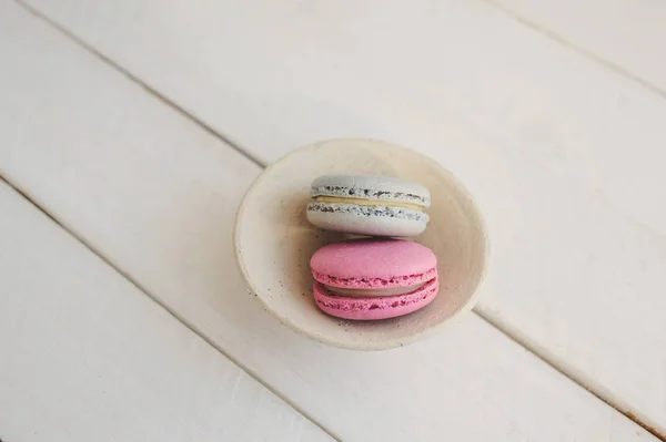 Renkli macaroons yukarıdaki üzerinden Beyaz ahşap zemin üzerinde. Metin için yer. 
