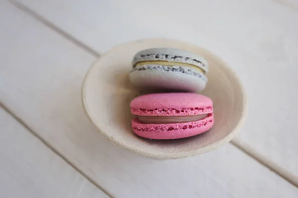 Renkli macaroons yukarıdaki üzerinden Beyaz ahşap zemin üzerinde. Metin için yer. 