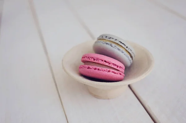 Renkli macaroons yukarıdaki üzerinden Beyaz ahşap zemin üzerinde. Metin için yer. 
