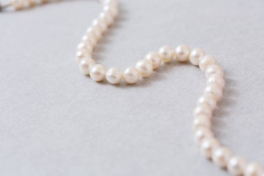 İnci iplik açık pembe inci arka planı üzerinde bir dalga ile ayarlandı