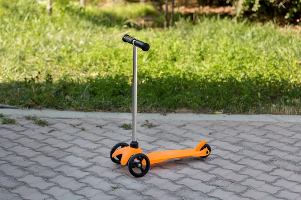 Uma Scooter Infantil Laranja Fica Estrada Verão Descanso Desporto — Fotografia de Stock