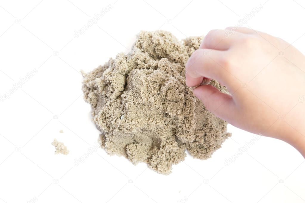 Child playing with kinetic sand. Hand of the child in the sand c