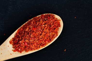 Kırmızı zemin sıcak acı biber bir tahta kaşık koyu siyah taş arka plan üzerinde Kazıklı Zemin