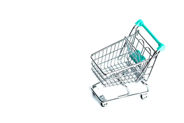 Carrinho de compras vazio em miniatura cor turquesa sobre fundo branco. isolado. Vista superior, flat lay — Fotografia de Stock