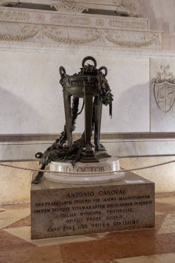 Bronze sculpture Installed near the tomb of Antonio Canova in the Canova Temple in Possagno, Italy.  of a classical monument with intricate details, featuring a laurel wreath and symbolic elements