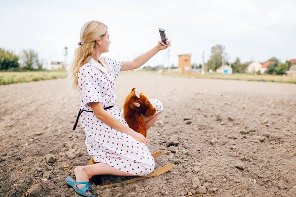 Vacker Blond Kvinna Tar Selfie Smartphone Medan Ridning Leksak Häst — Stockfoto