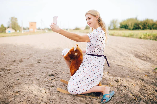 Vacker Blond Kvinna Tar Selfie Smartphone Medan Ridning Leksak Häst — Stockfoto
