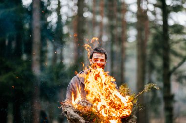 yanan odun elinde tutan genç adam