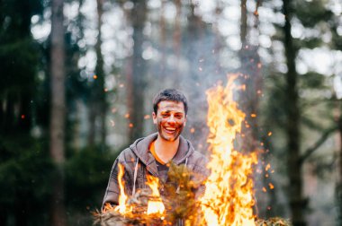 yanan odun elinde tutan genç adam