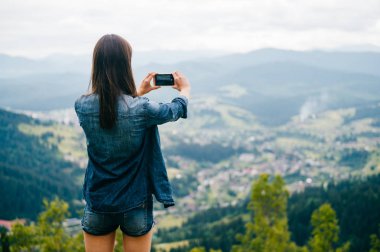 arkadan görünüşü güzel dağlar Smartphone cep telefonu ile fotoğraf çekimi kadın