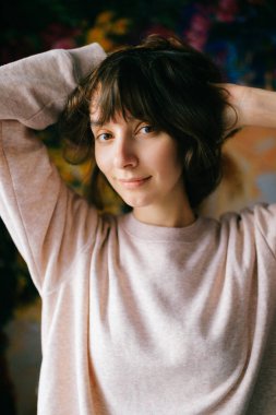 Genç güzel uzun saçlı esmer kadın kameraya bakıyor