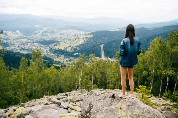背景上美丽的山脉的孤独的年轻旅行者的背视图 — 图库照片
